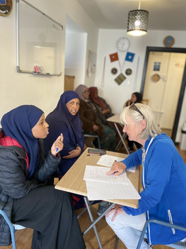 Women learning English with a volunteer teacher